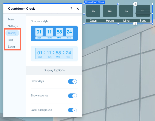 צילום מסך של אפליקציית Wix Countdown Clock ב-Wix Editor. חלונית ההגדרות פתוחה, והטאבים Display, Text ו-Design מסומנים.