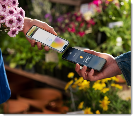 Zwei Personen halten Telefone in der Hand, um kontaktlos zu bezahlen